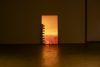 A vertical tv screen with an image of a city in the evening with red, orange yellow light.