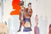 A close up of a mobile of a painted portraits of a couple in blue, purple and black.